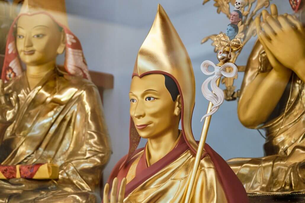Side on view of a golden statue of buddhist teacher and meditation master Venerable Geshe Kelsang Gyatso