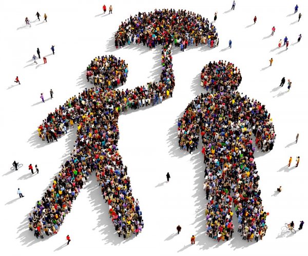 A crowd of people forming an image of someone holding an umbrella to protect someone else, as seen from above.