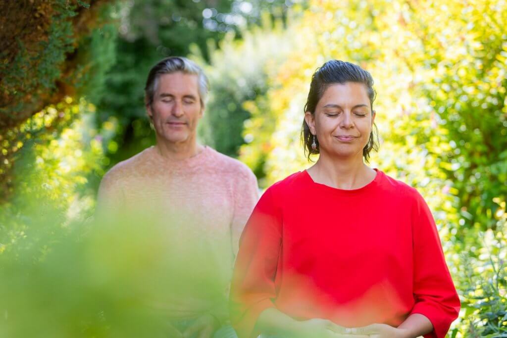 a man and a woman peacefully meditating in nature
